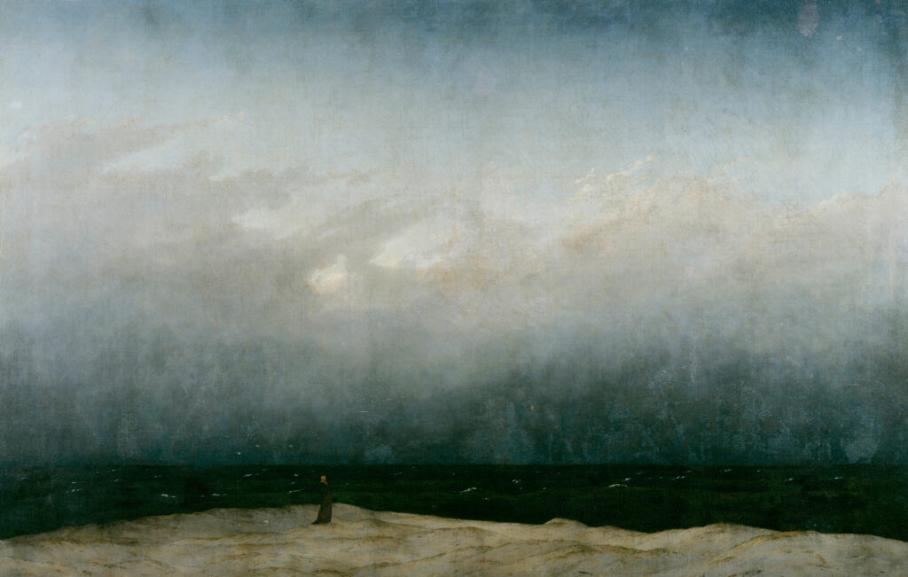 Peinture romantique de Caspar David Friedrich montrant une minuscule silhouette de moine debout sur une dune pâle. Il fait face à une mer noire et un immense ciel nuageux gris-bleu qui occupe les trois quarts de la toile, évoquant un sentiment de solitude face à l'immensité.